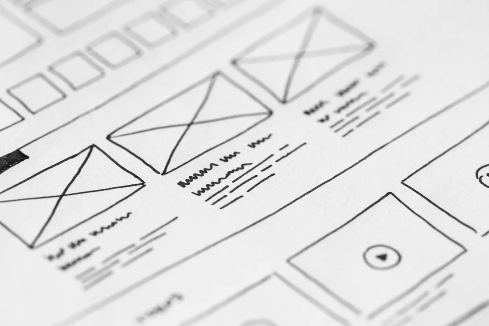 Writing on a paper that looks like the beginning blueprint of a new website