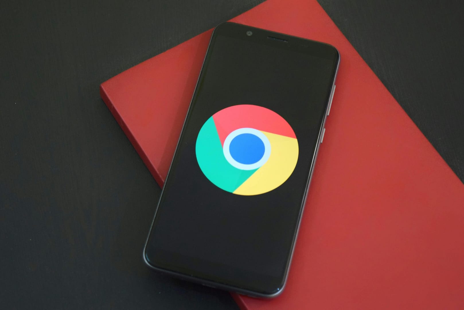 Phone opened to Google App situated on a red book