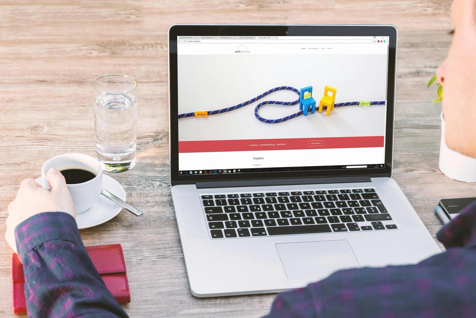 Man sitting at a wooden table drinking black coffee from a mug, looks like he is working on his website page speed.