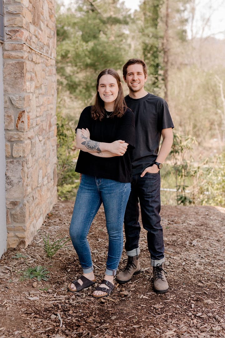 Folded Co-owners of Barefoot Build stand outside smiling