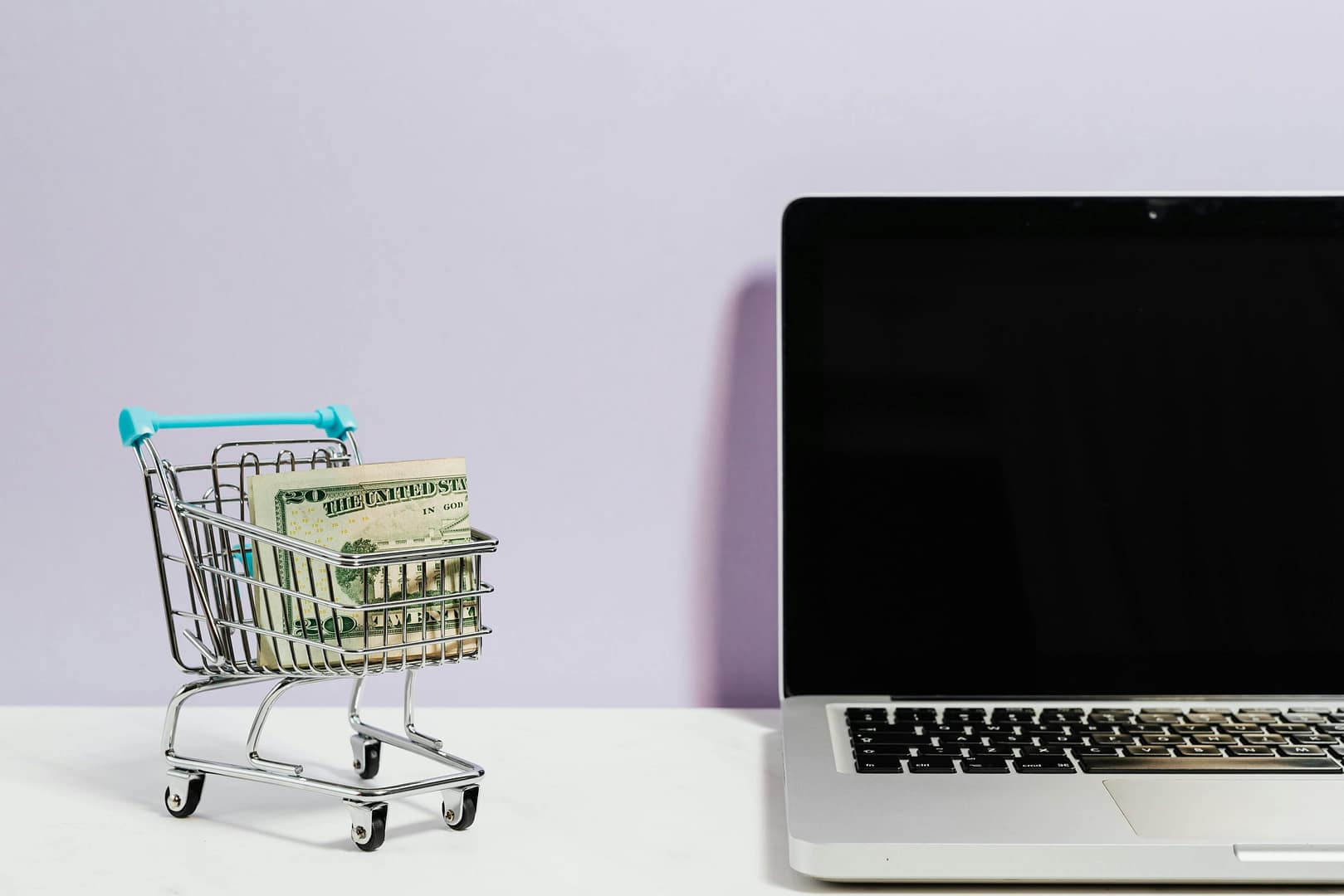 Shopping cart next to a computer alluding to an online sale
